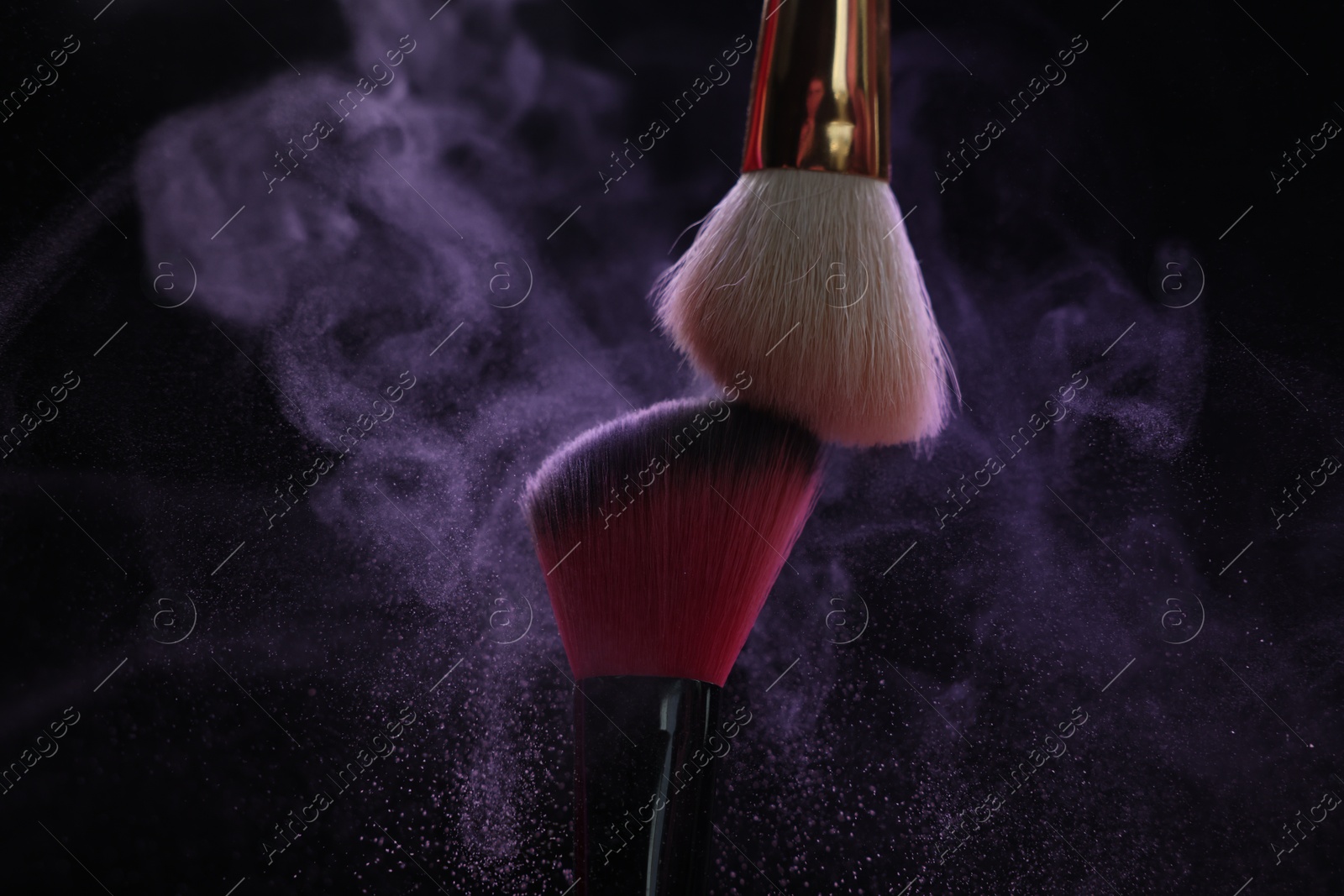 Makeup brushes with purple eye shadow on black background, closeup Photo of Makeup brushes with purple eye shadow on black background, closeup