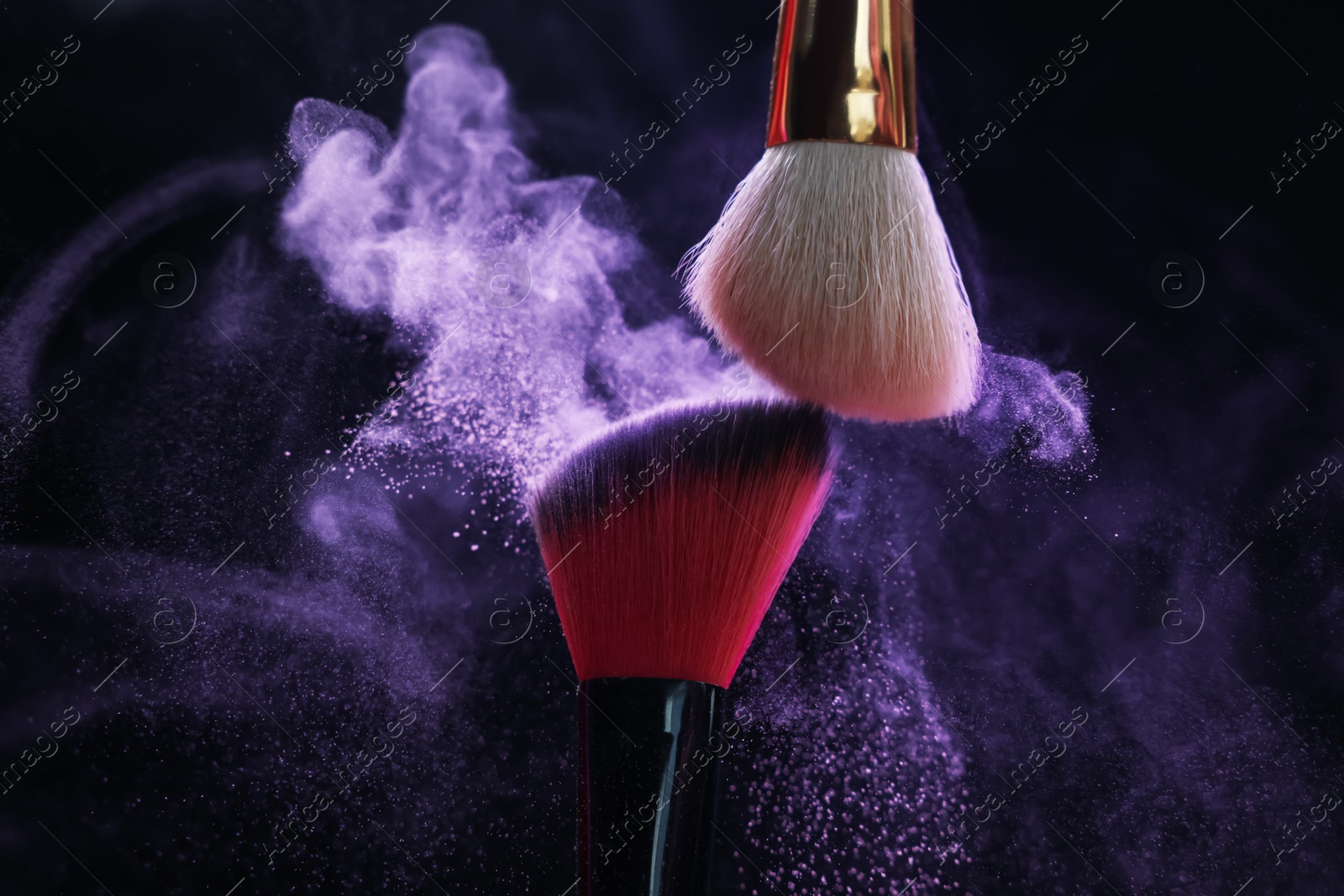 Makeup brushes with purple eye shadow on black background, closeup Photo of Makeup brushes with purple eye shadow on black background, closeup