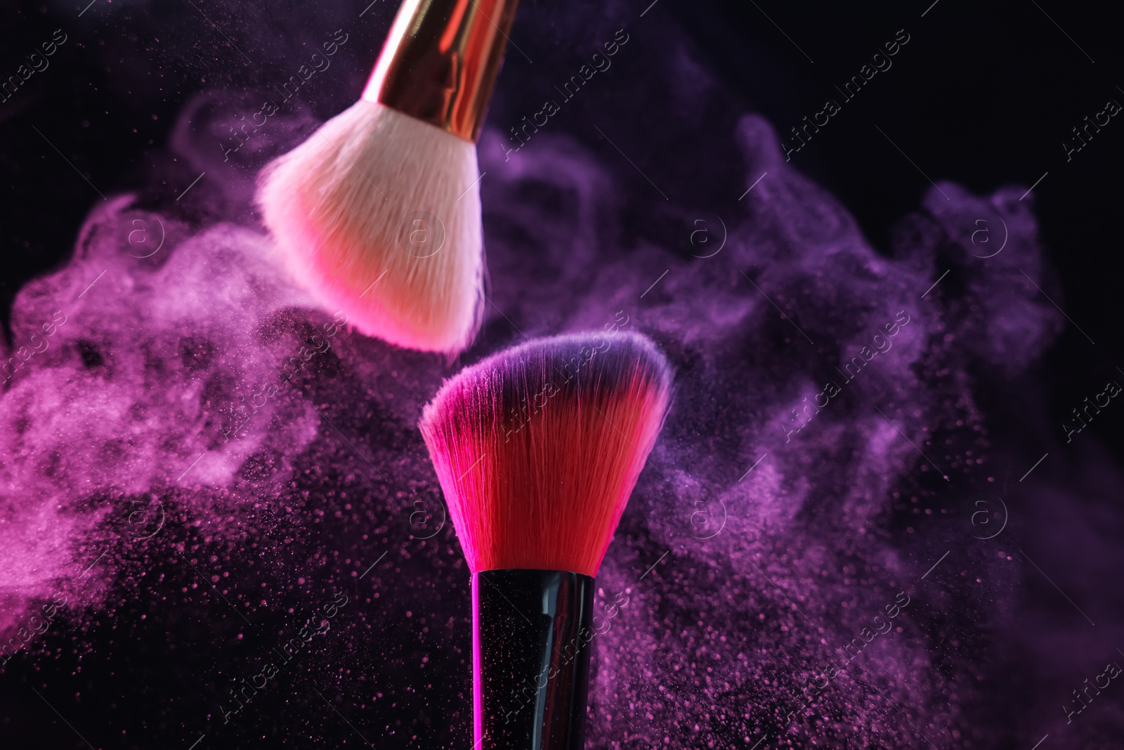 Makeup brushes with colorful eye shadows in neon lights on black background, closeup Photo of Makeup brushes with colorful eye shadows in neon lights on black background, closeup