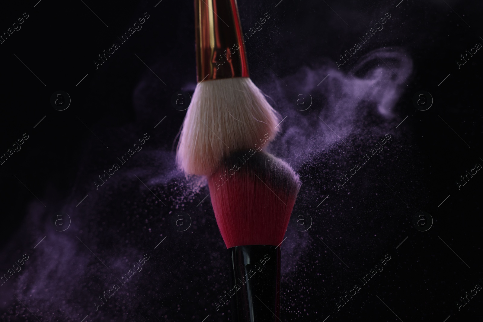 Makeup brushes with purple eye shadow on black background, closeup Photo of Makeup brushes with purple eye shadow on black background, closeup