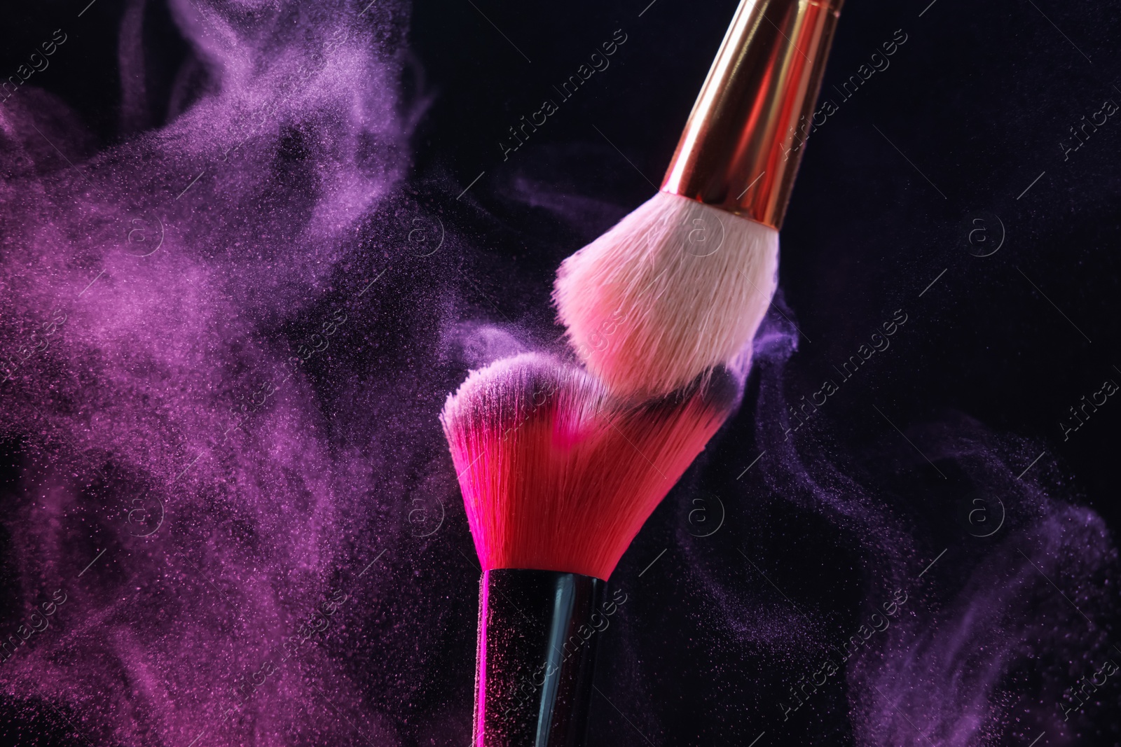 Photo of Makeup brushes with color eye shadow on black background, closeup