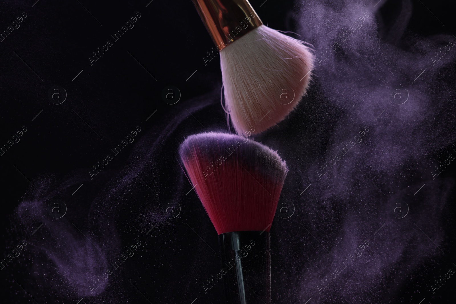 Makeup brushes with purple eye shadow on black background, closeup Photo of Makeup brushes with purple eye shadow on black background, closeup