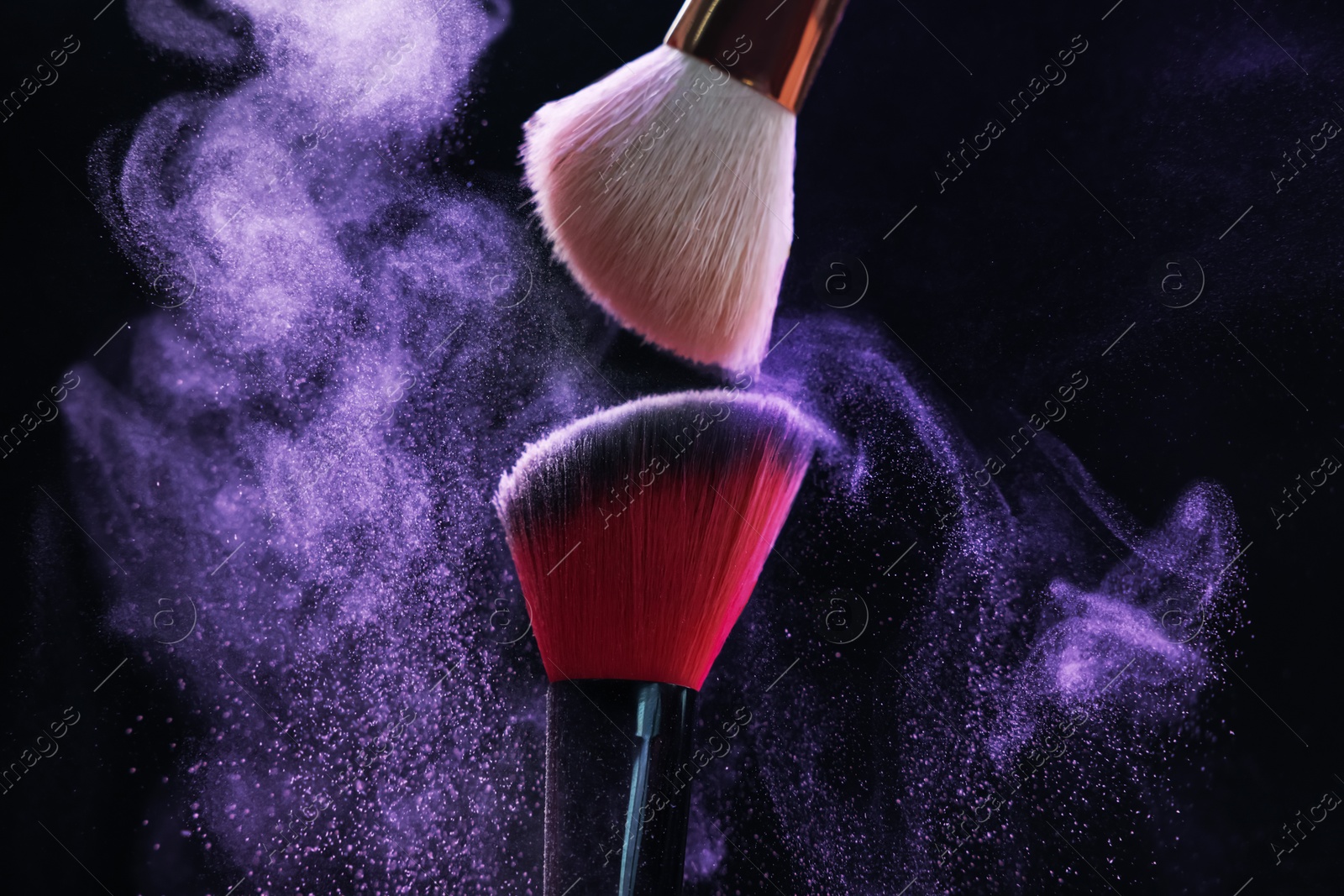 Makeup brushes with purple eye shadow on black background, closeup Photo of Makeup brushes with purple eye shadow on black background, closeup