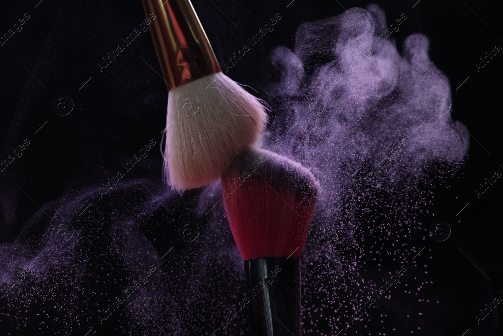 Makeup brushes with purple eye shadow on black background, closeup Photo of Makeup brushes with purple eye shadow on black background, closeup