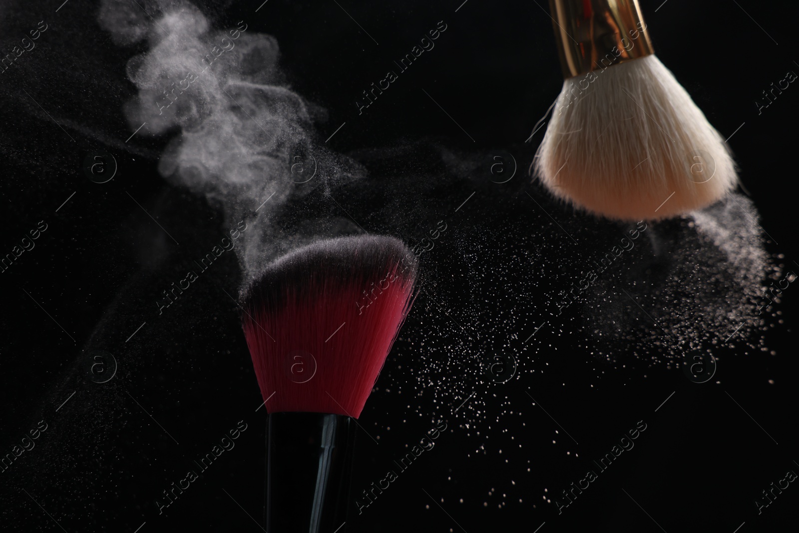 Makeup brushes with cosmetic powder on black background, closeup Photo of Makeup brushes with cosmetic powder on black background, closeup