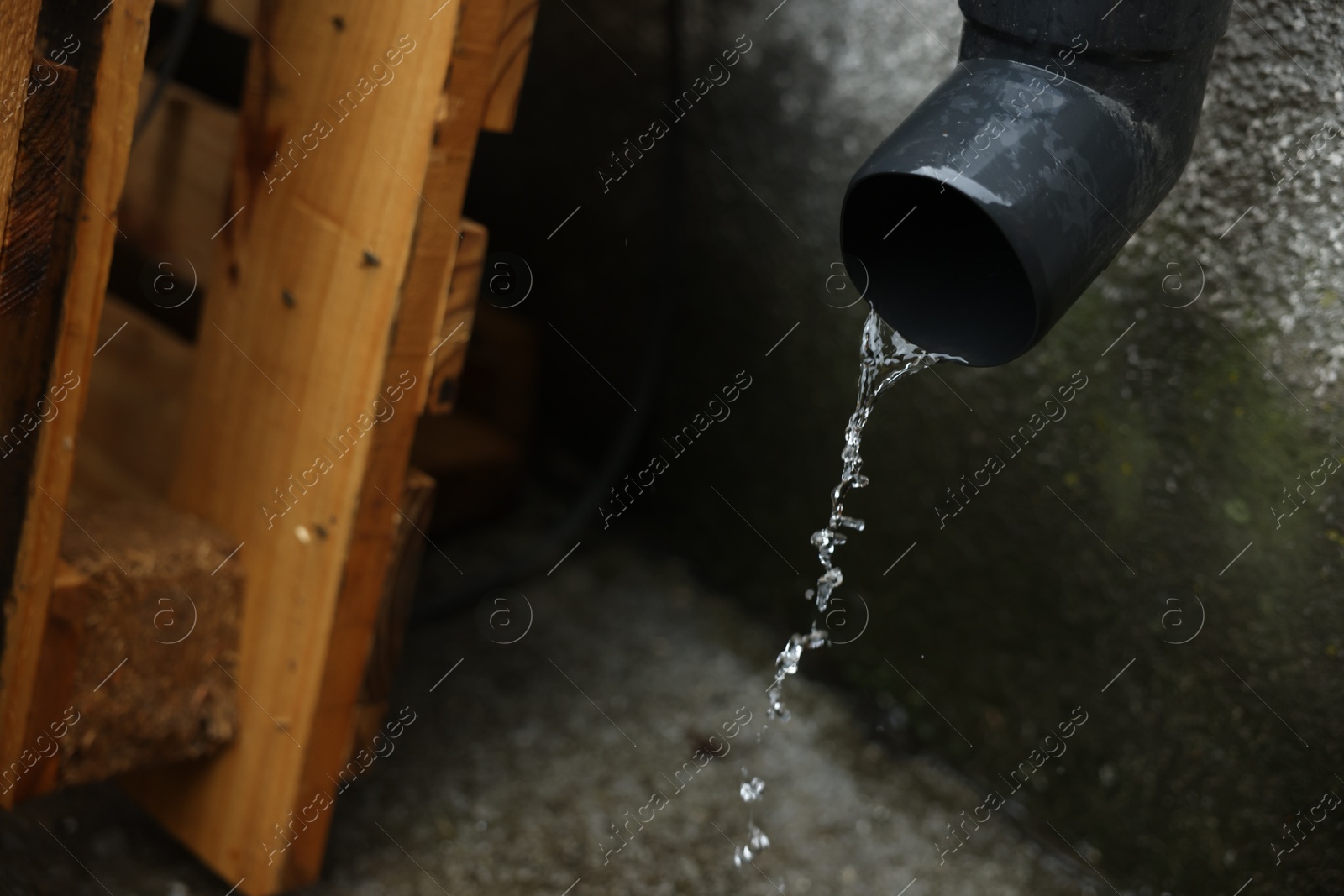 Water flowing from drain pipe outdoors, closeup Photo of Water flowing from drain pipe outdoors, closeup