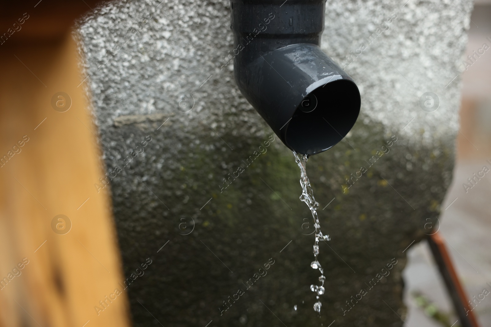 Water dripping from drain pipe outdoors, closeup Photo of Water dripping from drain pipe outdoors, closeup