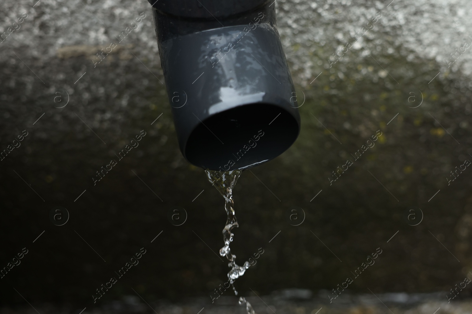 Water dripping from drain pipe outdoors, above view. Space for text Photo of Water dripping from drain pipe outdoors, above view. Space for text