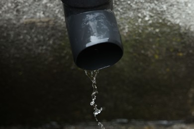 Photo of Water dripping from drain pipe outdoors, above view. Space for text