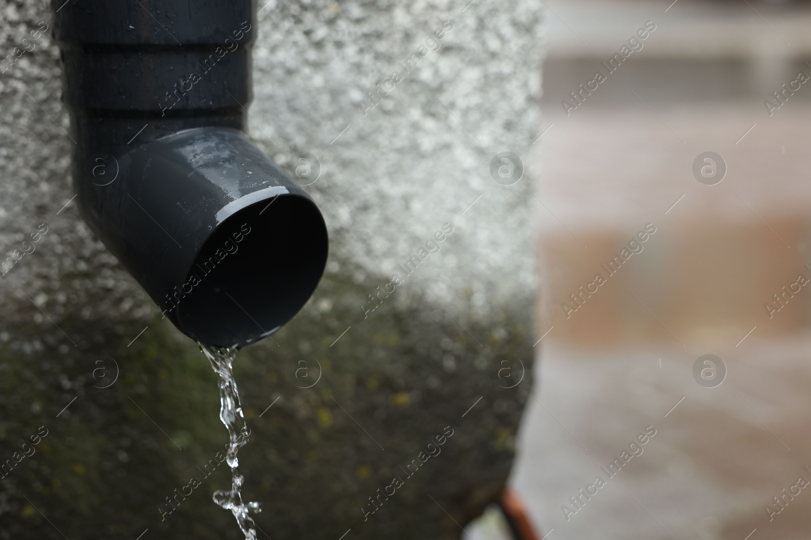 Water dripping from drain pipe outdoors, closeup. Space for text Photo of Water dripping from drain pipe outdoors, closeup. Space for text