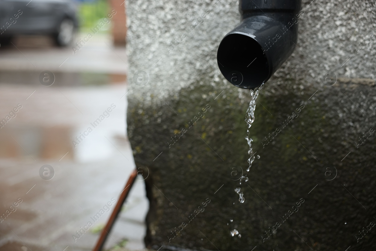 Water dripping from drain pipe outdoors, closeup. Space for text Photo of Water dripping from drain pipe outdoors, closeup. Space for text