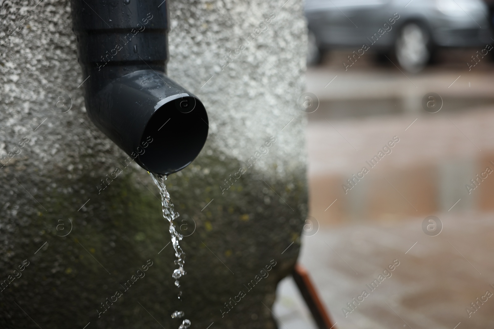 Water dripping from drain pipe outdoors, closeup. Space for text Photo of Water dripping from drain pipe outdoors, closeup. Space for text