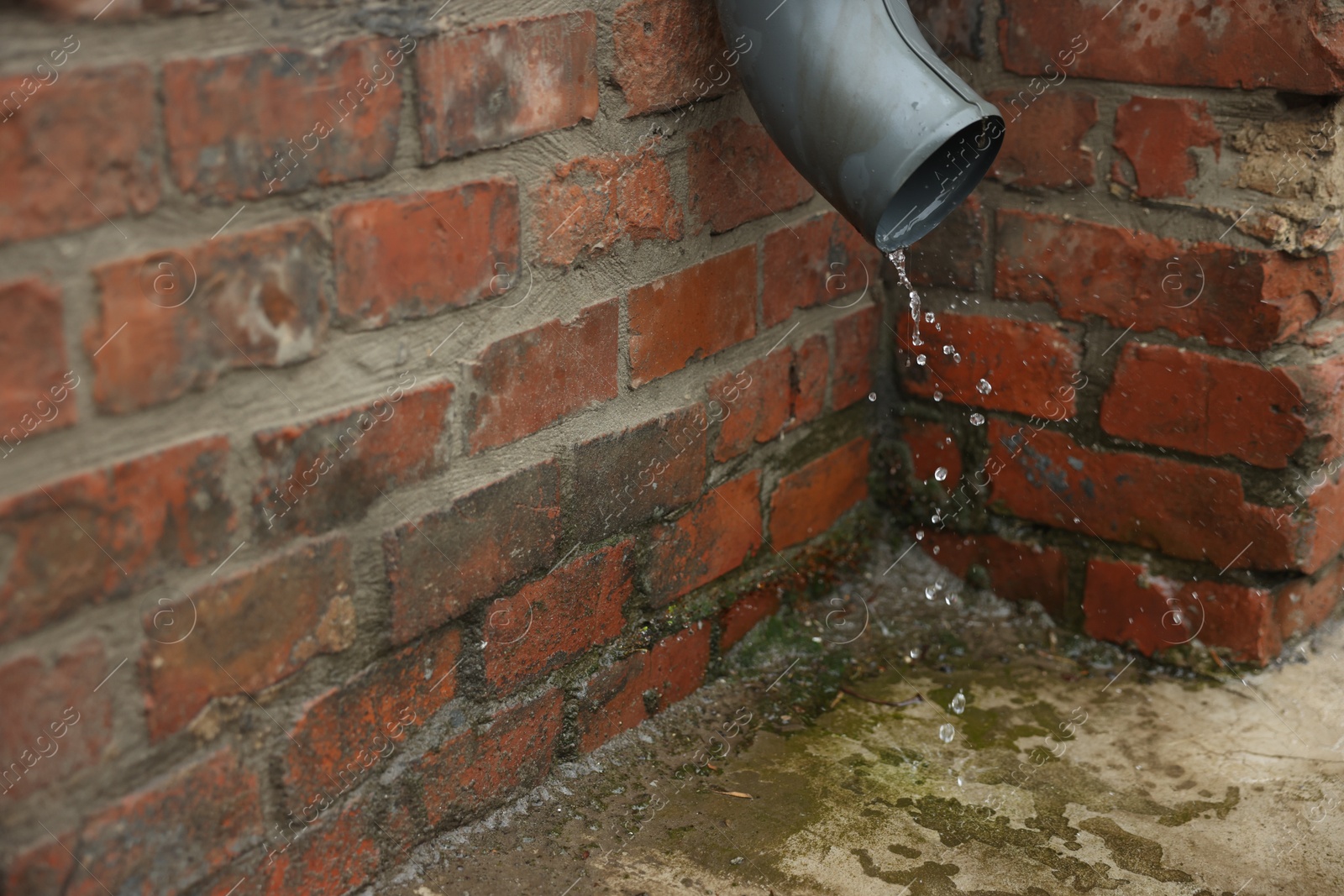 Water dripping from drain pipe outdoors, closeup Photo of Water dripping from drain pipe outdoors, closeup