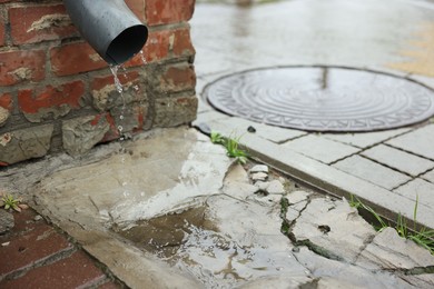 Photo of Water dripping from drain pipe outdoors, space for text