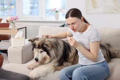Photo of Woman suffering from allergy with her dog at home