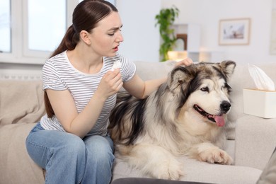 Photo of Woman suffering from allergy with her dog at home