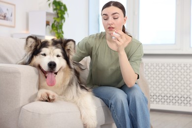 Photo of Woman suffering from allergy with her dog at home