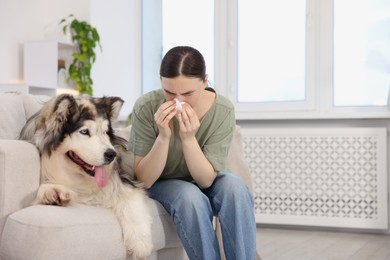 Photo of Woman suffering from allergy with her dog at home. Space for text