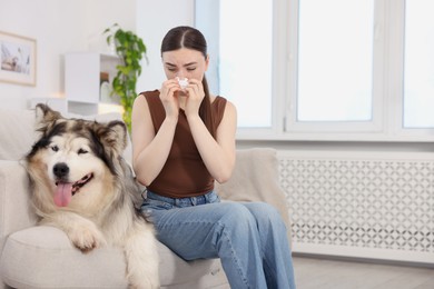 Photo of Woman suffering from allergy with her dog at home. Space for text