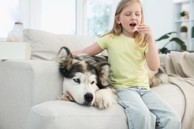 Photo of Girl suffering from allergy with her dog at home