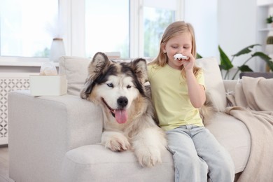 Photo of Girl suffering from allergy with her dog at home