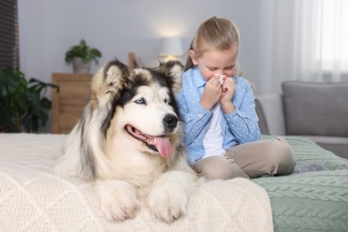 Photo of Girl suffering from allergy with her dog on bed at home