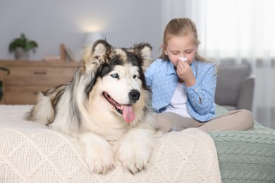 Photo of Girl suffering from allergy with her dog on bed at home