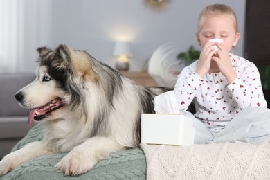 Photo of Girl suffering from allergy with her dog on bed at home