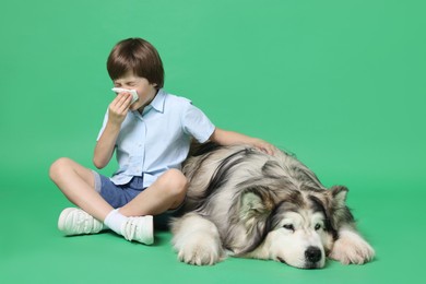 Photo of Boy suffering from allergy with her dog on green background. Space for text