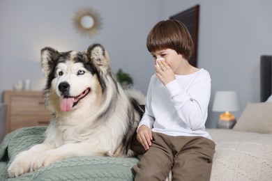 Photo of Boy suffering from allergy with her dog on bed at home
