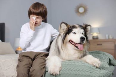Photo of Boy suffering from allergy with her dog on bed at home
