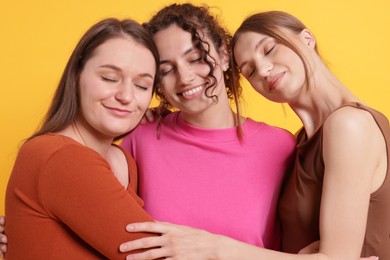 Photo of Friends hugging each other on orange background