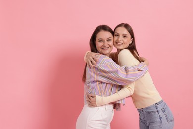 Photo of Friends hugging on pink background, space for text