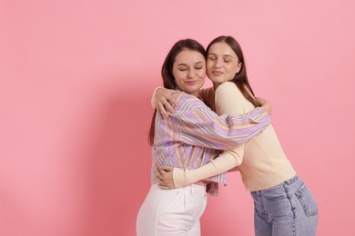 Photo of Friends hugging on pink background, space for text