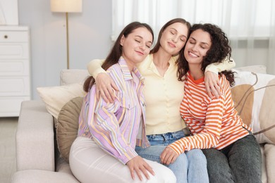Photo of Friends hugging each other on sofa indoors