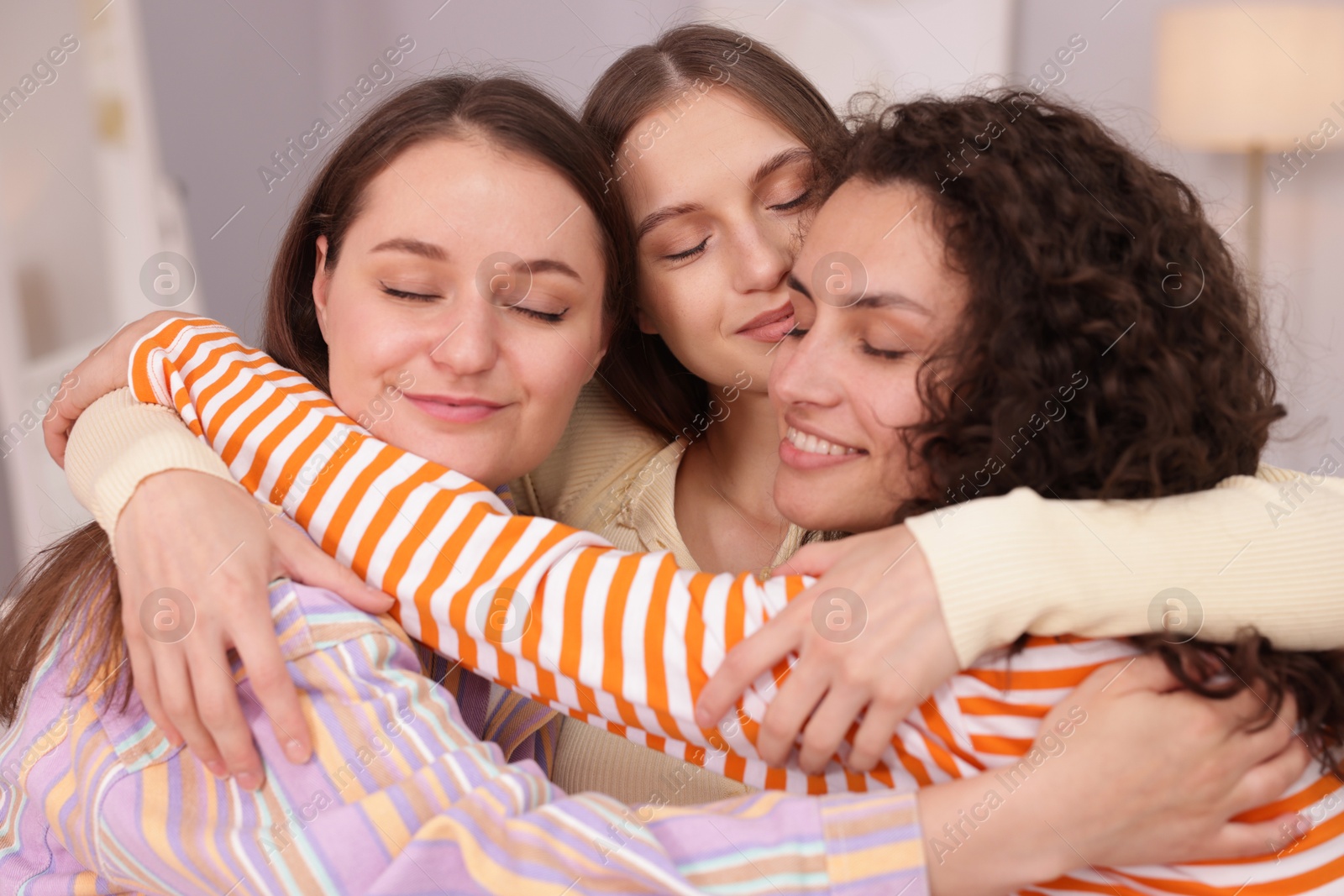Three friends hugging each other at home Photo of Three friends hugging each other at home