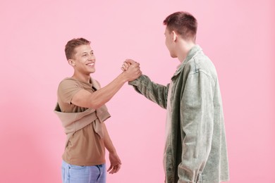 Photo of Friends welcoming each other on pink background