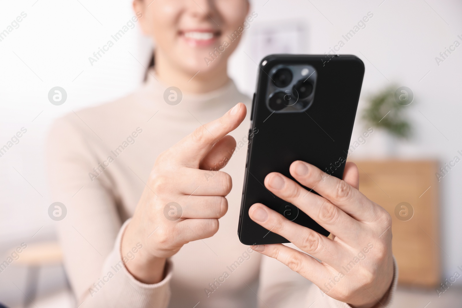 Woman using modern smartphone at home, closeup Photo of Woman using modern smartphone at home, closeup