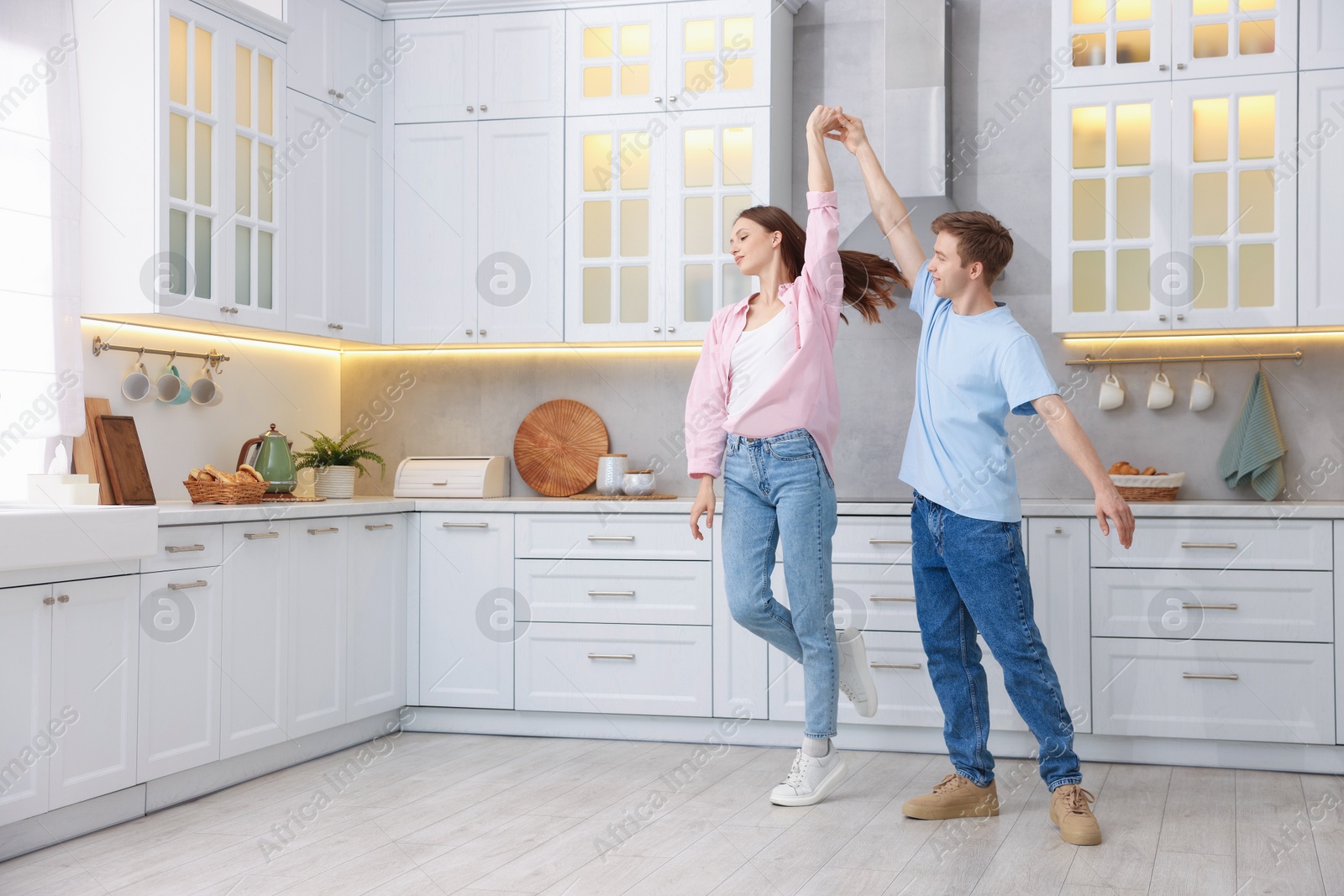 Happy young couple dancing together in kitchen Photo of Happy young couple dancing together in kitchen