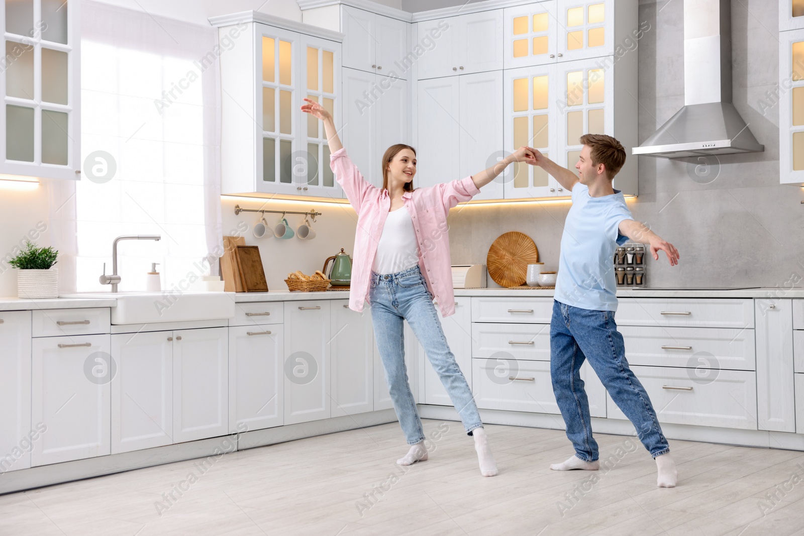 Happy young couple dancing together in kitchen Photo of Happy young couple dancing together in kitchen