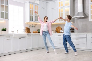 Photo of Happy young couple dancing together in kitchen