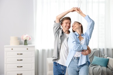 Photo of Happy couple dancing at home. Space for text