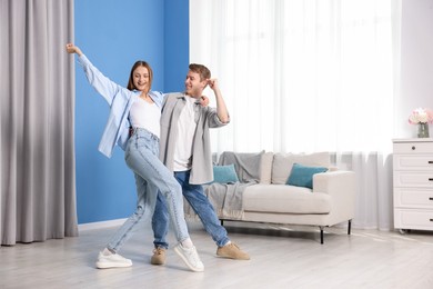 Photo of Happy young couple dancing together at home