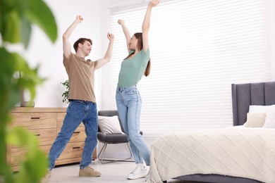 Photo of Happy young couple dancing together in bedroom