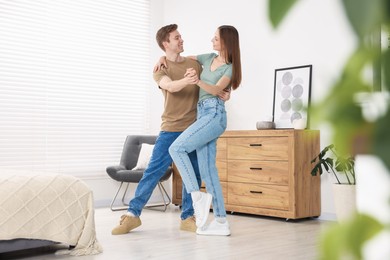 Photo of Happy young couple dancing together at home