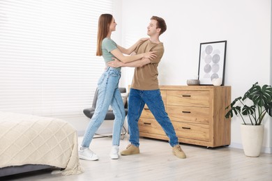 Photo of Happy young couple dancing together at home