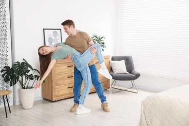 Photo of Happy young couple dancing together at home