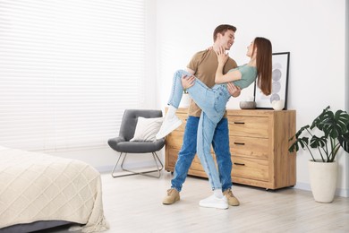 Photo of Happy young couple dancing together at home