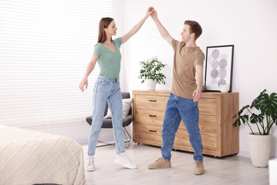 Photo of Happy young couple dancing together at home