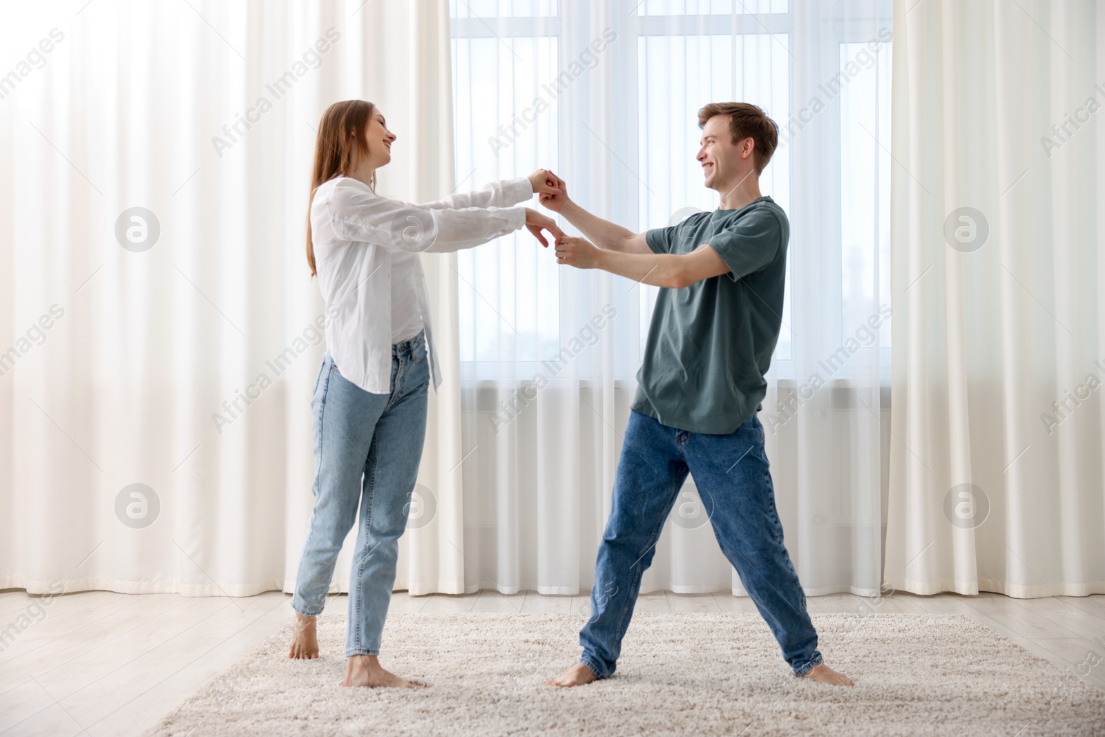 Happy young couple dancing together at home Photo of Happy young couple dancing together at home